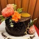Chocolate truffle cake with floral decoration and anniversary theme design