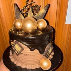 Chocolate truffle designer cake with black ganache drip and gold decoration balls
